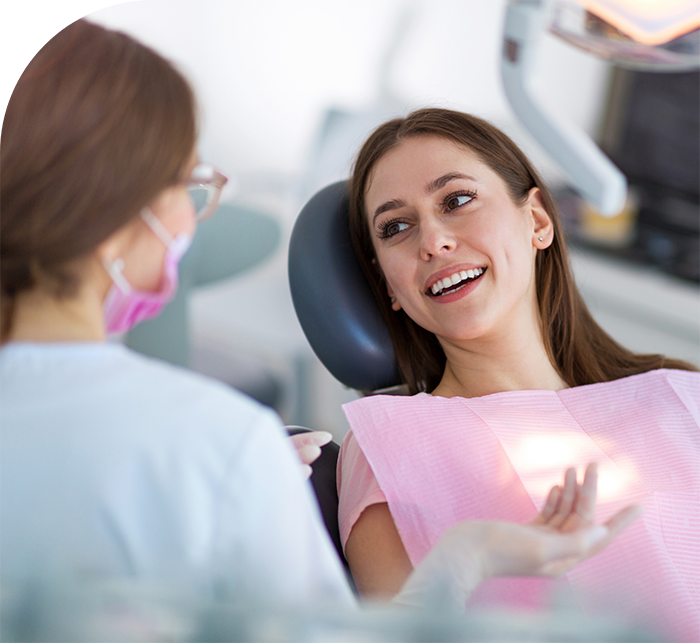 Woman in dental chair talking to her dentist in White Marsh