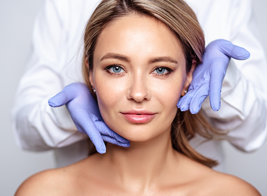 Cosmetic dentist gesturing to woman smiling after Botox and Xeomin treatment