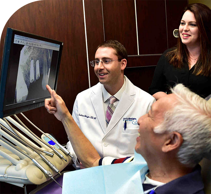 Dentist showing a patient his x ray with dental implants in White Marsh