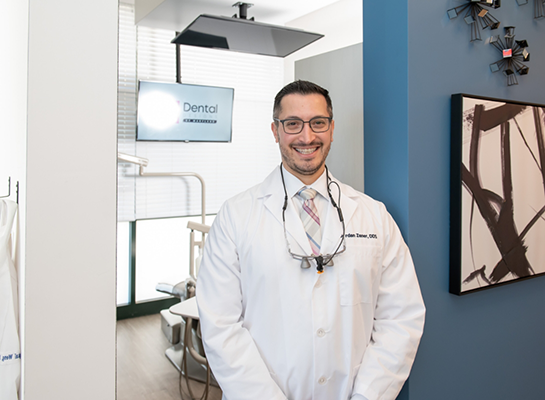 Smiling White Marsh dentist standing outside of treatment room