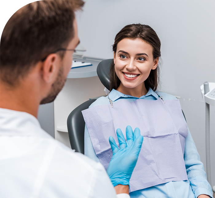 Woman in dental chair listening to her dentist talk