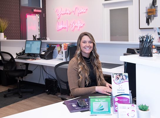 Dental office receptionist smiling at front desk