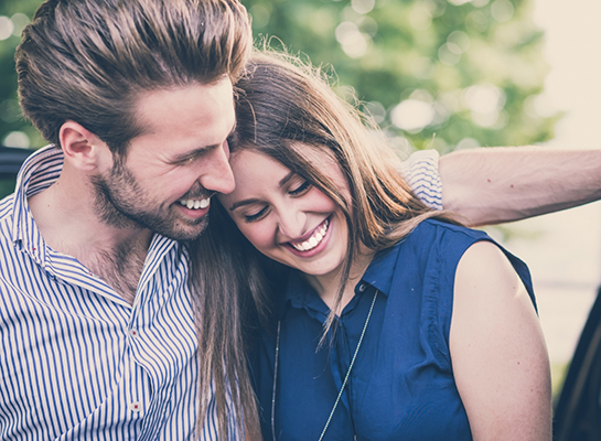 Man and woman laughing together outdoors