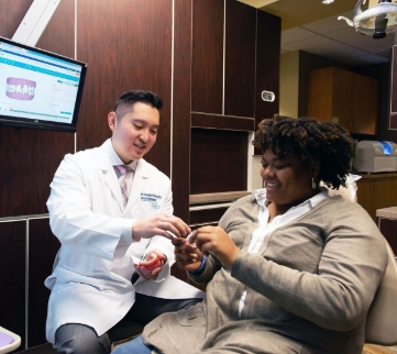 Dentist showing a model of teeth to a patient