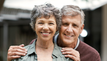 Senior man and woman smiling and hugging