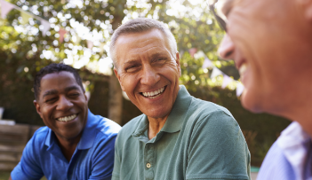 Three men laughing together outdoors