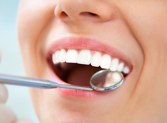 Close up of smiling mouth and dental mirror