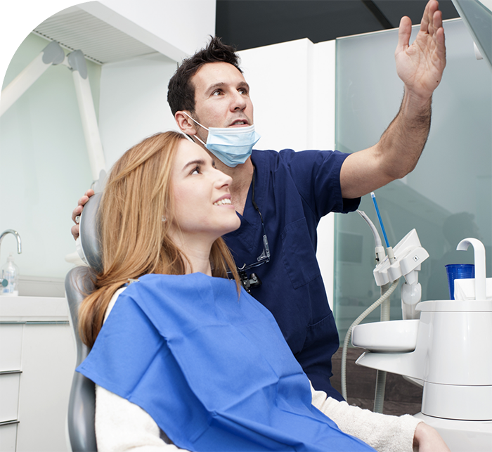 Restorative dentist showing a screen to a patient