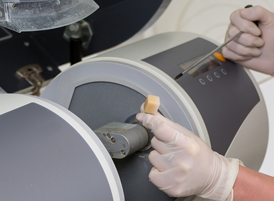 Dentist placing a ceramic block in CEREC same day dental crown machine