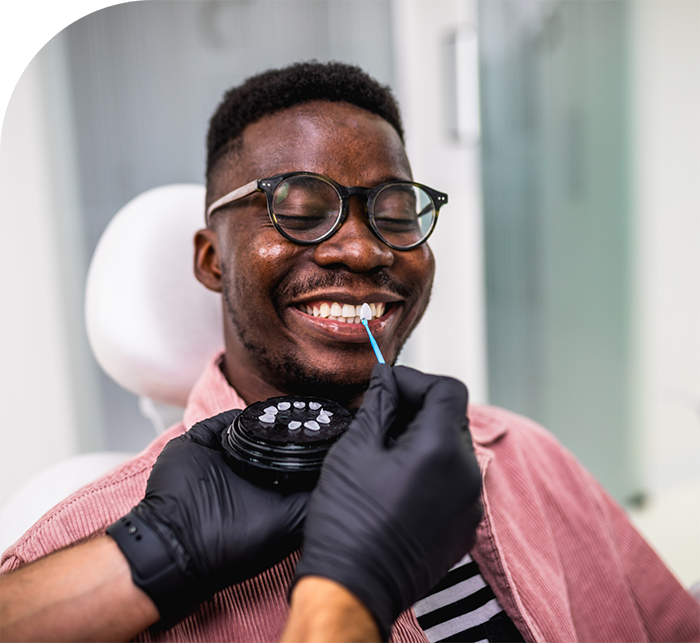 Man grinning while receiving dental veneers in White Marsh