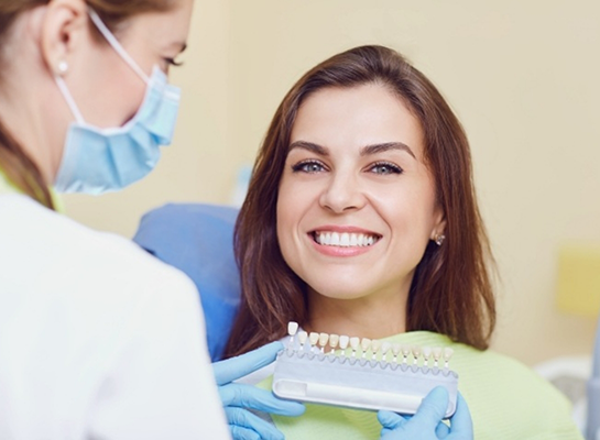 Dental patient smiling while receiving veneers